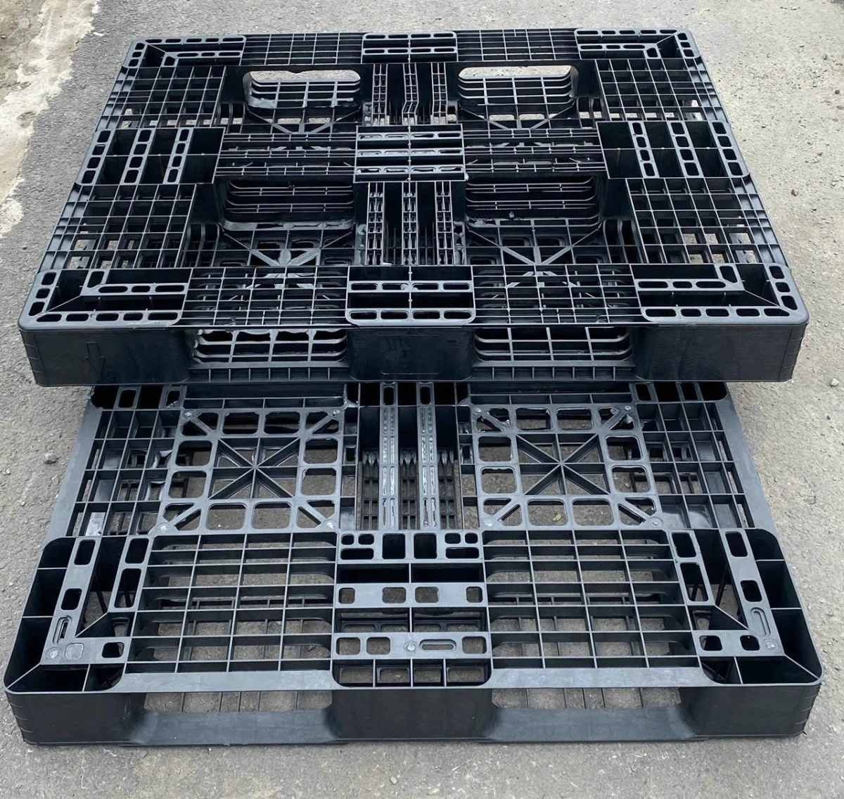 Pallet nhựa cũ 1200x1000x120mm mặt lưới màu đen, hai tấm xếp chồng tại kho