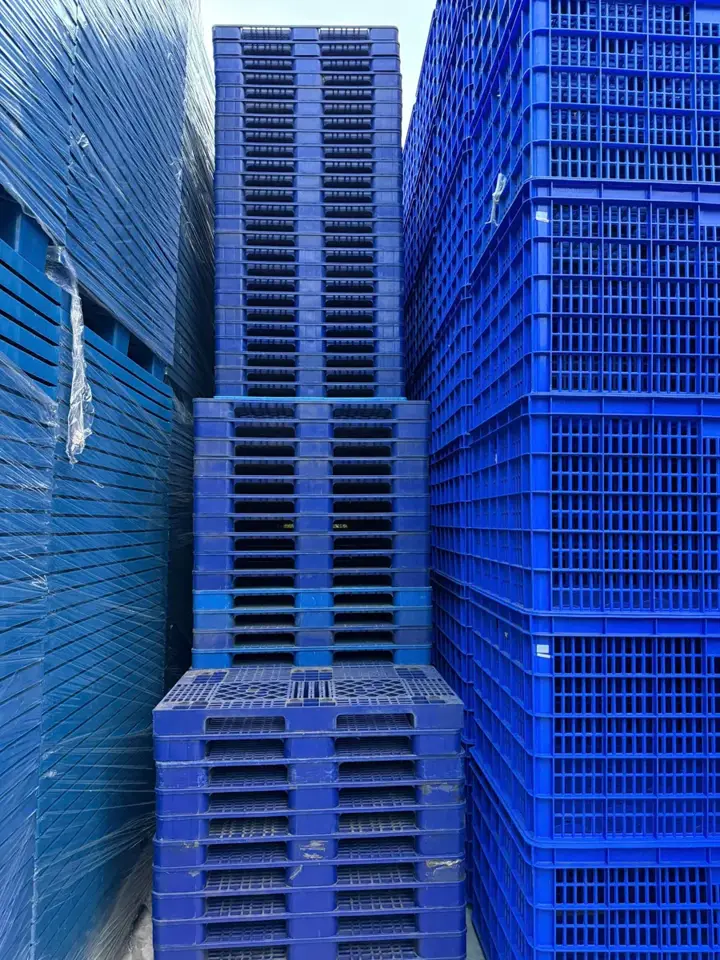 Pallet nhựa mới màu xanh xếp chồng tại kho